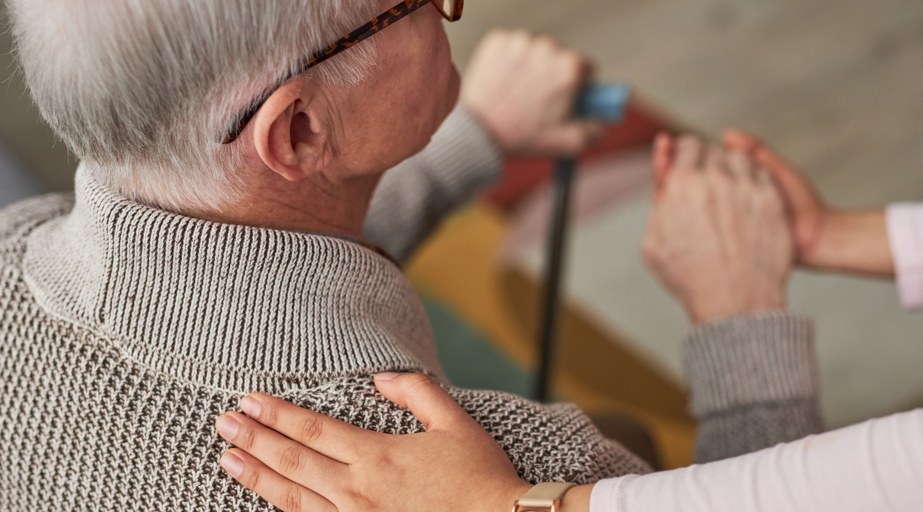 Elderly man being assisted into the bathtub using a sliding transfer bench for safe bathroom access